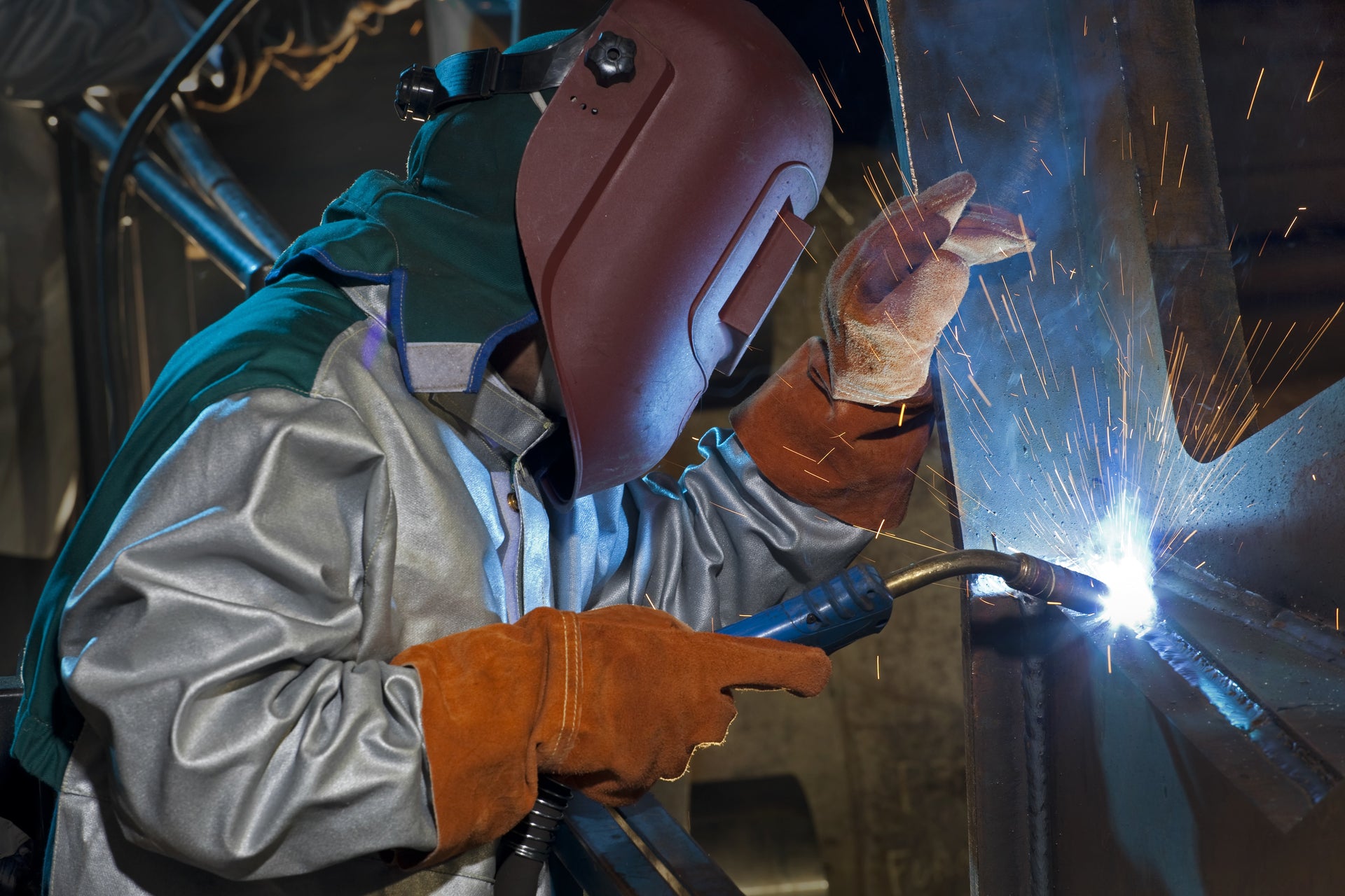 Saldatore al lavoro con abbigliamento anticalore Hotworks, indumenti certificati EN ISO 11611 e EN ISO 11612 per la protezione da calore e fiamma.