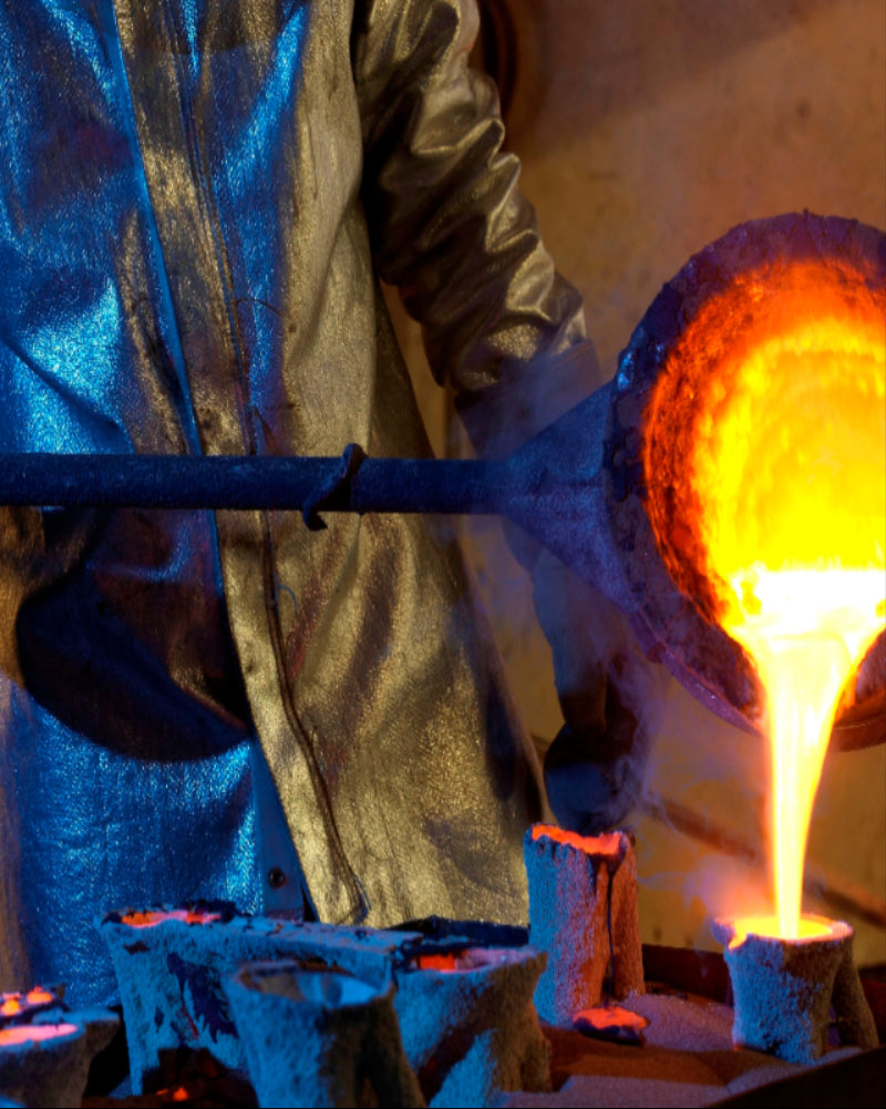 Operaio che fonde il metallo indossando abbigliamento protettivo alluminizzato anticalore Hotworks.